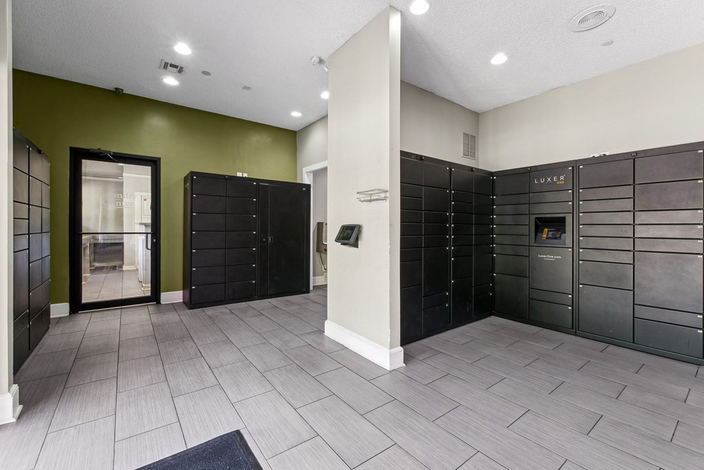 Package Lockers A room with a green wall and a row of black lockers at Elme Druid Hills, Atlanta, Georgia